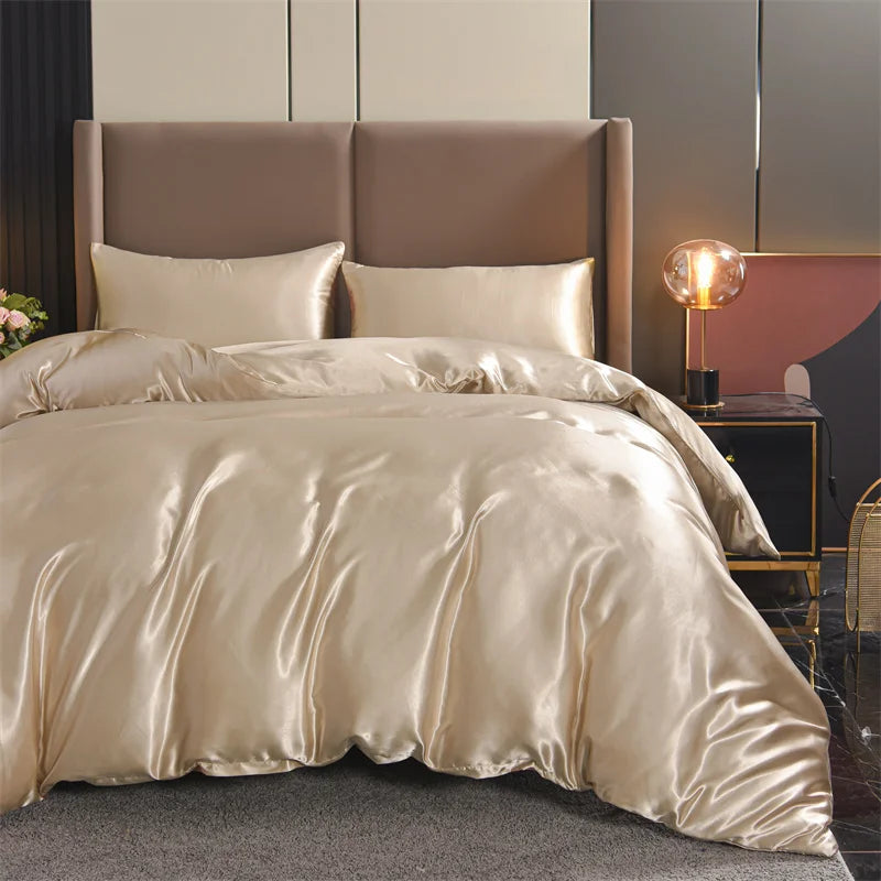 Housse de couette champagne satiné lisse sur un lit avec deux taies d’oreiller assorties, dans une chambre élégante et moderne.