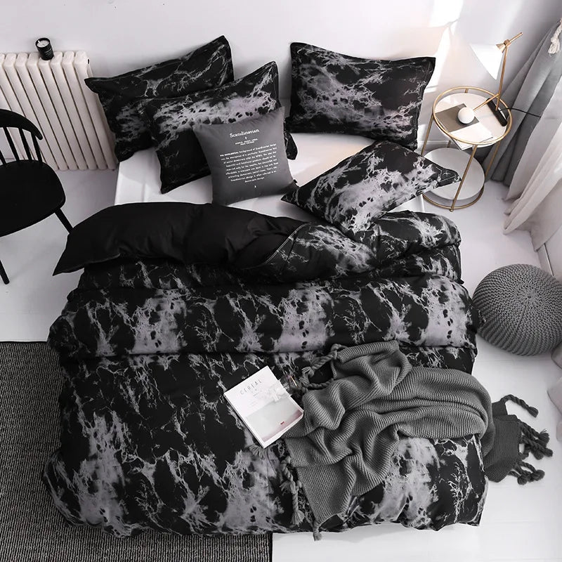 Housse de couette noire et grise à imprimé marbré avec deux taies d’oreiller assorties sur un lit moderne.