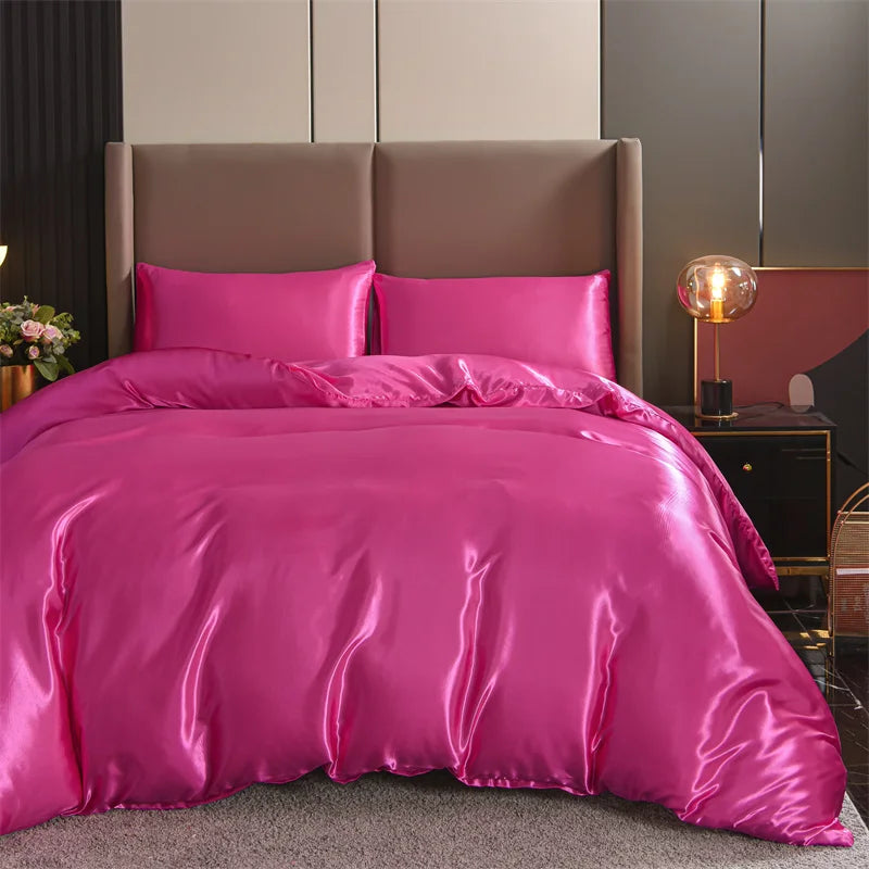 Housse de couette rose satiné lisse sur un lit avec deux taies d’oreiller assorties, dans une chambre élégante et moderne.
