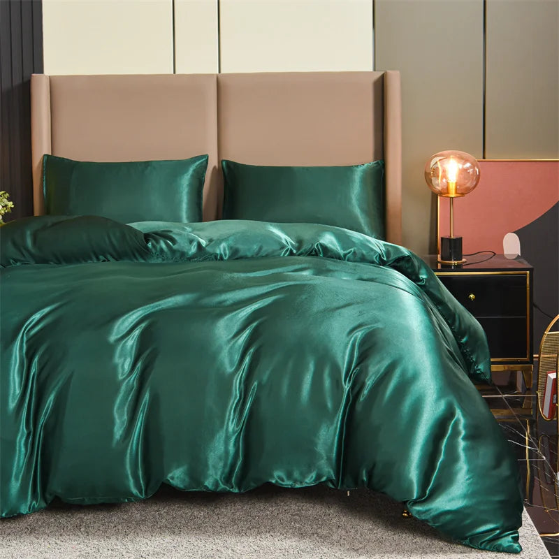 Housse de couette verte satiné lisse sur un lit avec deux taies d’oreiller assorties, dans une chambre élégante et moderne.