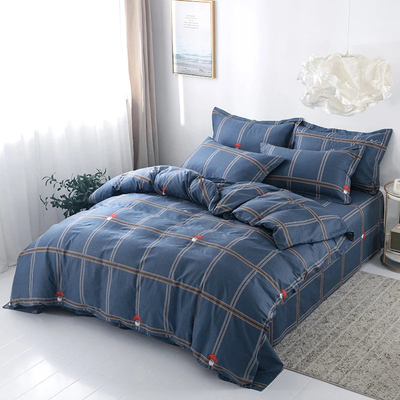 Housse de couette coton bleu à motif carreaux beige et marine, mise en scène sur un lit moderne.