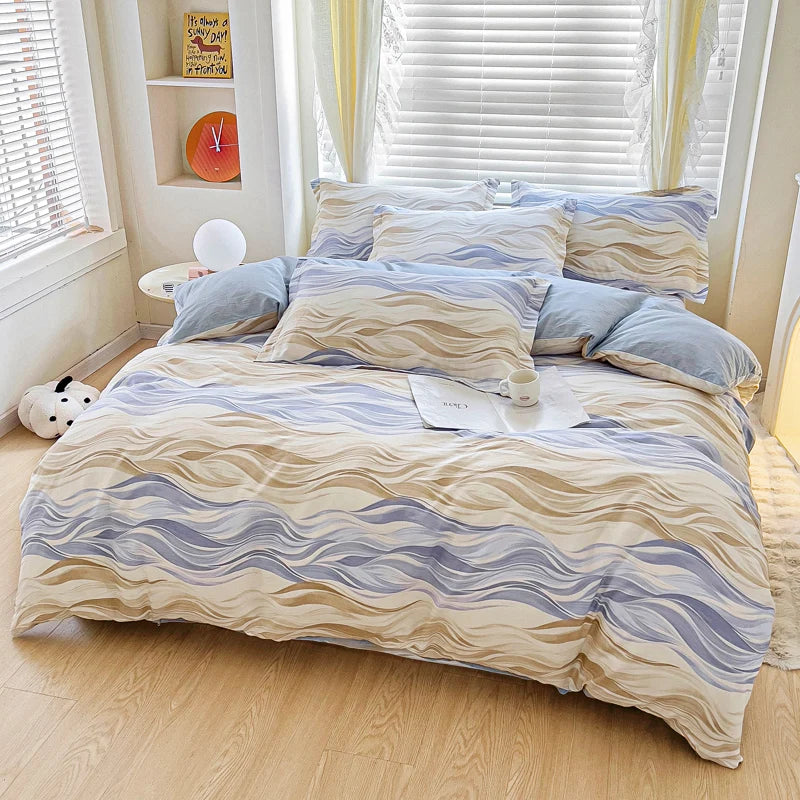 Housse de couette motif vagues pastel beige, crème et bleu clair drapée sur un lit moderne.