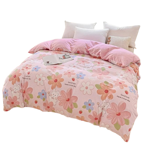 Housse de couette rose imprimée de grandes fleurs pastel et d’un lapin mignon, drapée sur un lit clair.