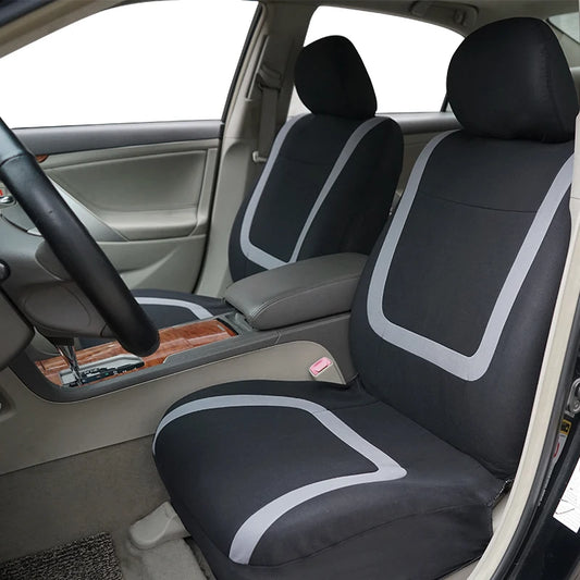 Set universel de housses de siège auto en polyester noir avec passepoil gris, couvrant sièges avant, banquette et appuie-têtes.